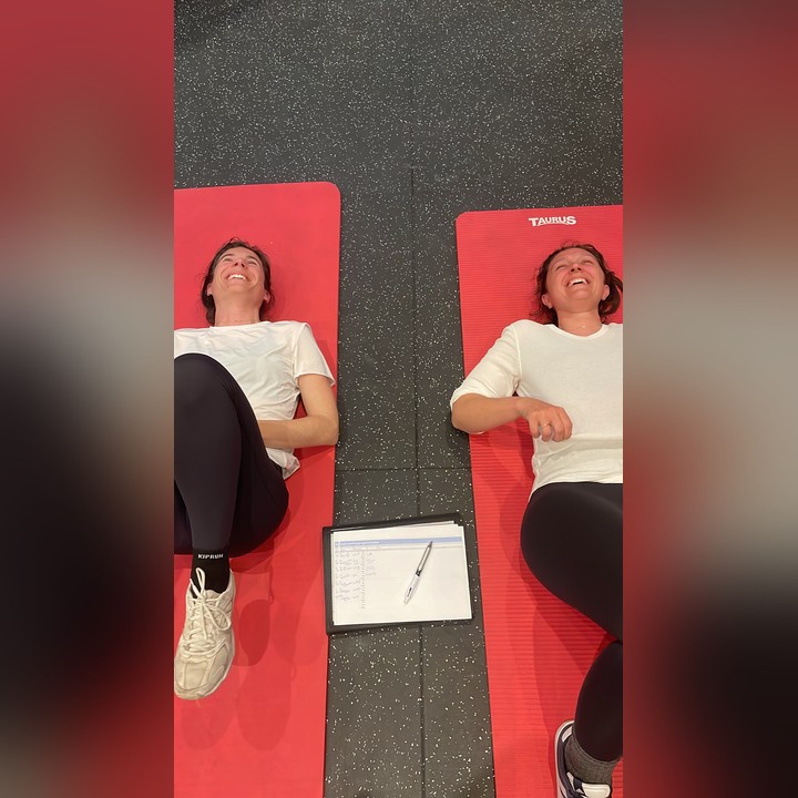 Deux clientes allongées sur leurs tapis à la fin d'une séance en duo, à côté du carnet de suivi Soul Coaching
